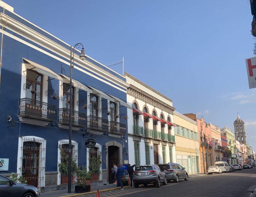 Farbige Kolonialfassaden in der Altstadt von Puebla mit den Türmen der Kathedrale im Hintergrund